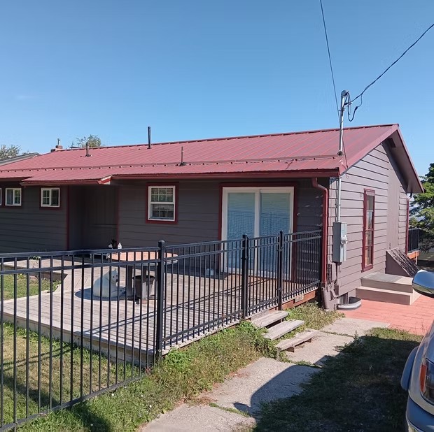 Red-roofed home behind a fence