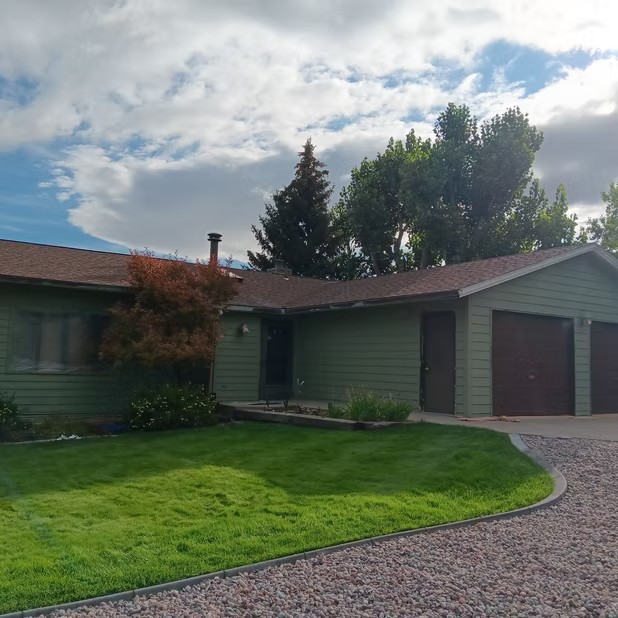 Home and garage beside a green lawn